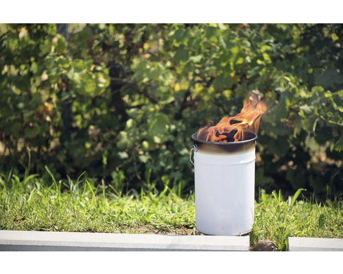 Feuerkorb aus Metall mit brennendem Inhalt im Garten