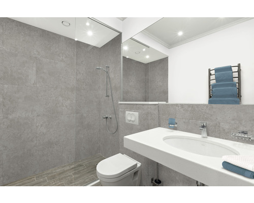 Badezimmer mit Dusche, Toilette, Waschbecken und Handtuchwärmer