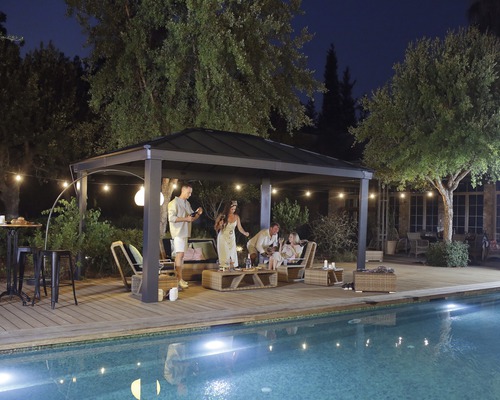 Gartenszene mit Pavillon, Gartenmöbeln und Pool bei Nacht