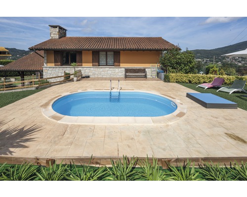 Ovaler Pool im Garten eines Wohnhauses mit Terrasse