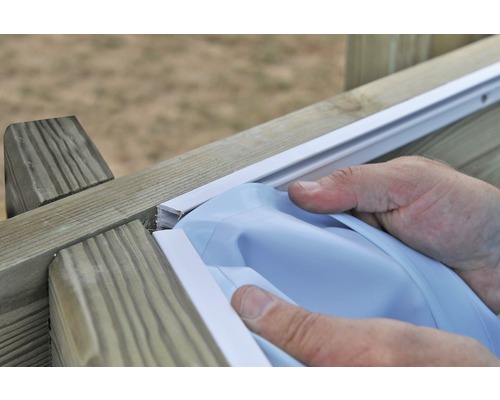 Person befestigt eine Poolfolie an einem Holzrahmen.