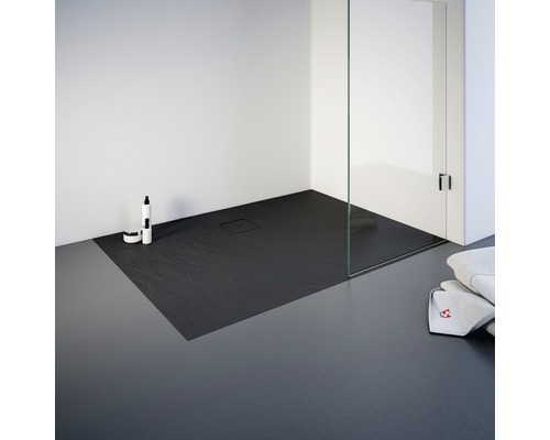 Ebenerdige Dusche mit Duschwanne aus Stein, Duschabtrennung aus Glas und Handtüchern