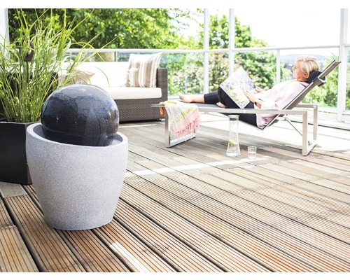 Dekorative Terrasse mit Kugelbrunnen, Liegestuhl und Sitzgelegenheit