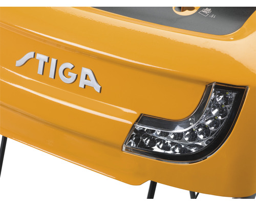 Detailansicht eines gelben Stiga Rasentraktors mit Stiga Logo und Scheinwerfer