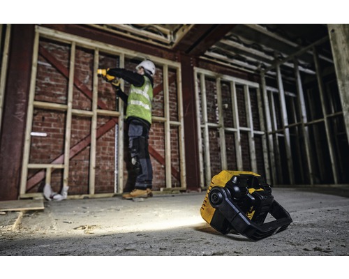 Baustellenszene mit Arbeiter, der mit einer Akku-Lampe arbeitet