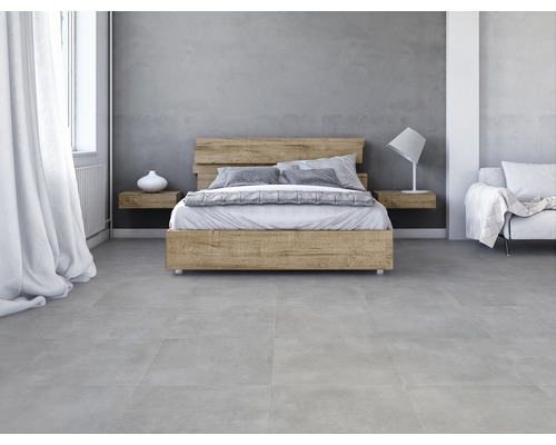 Schlafzimmer mit Holzbett, Nachttischen und grauen Bodenfliesen.