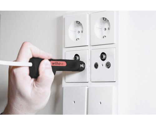 Hand mit Wiha Schraubendreher an Antennenanschlussdose