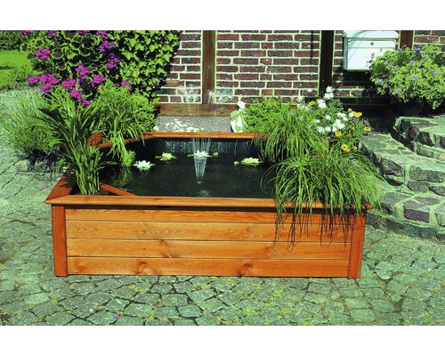 Holzteich mit Fontäne, Seerosen und Bepflanzung im Garten