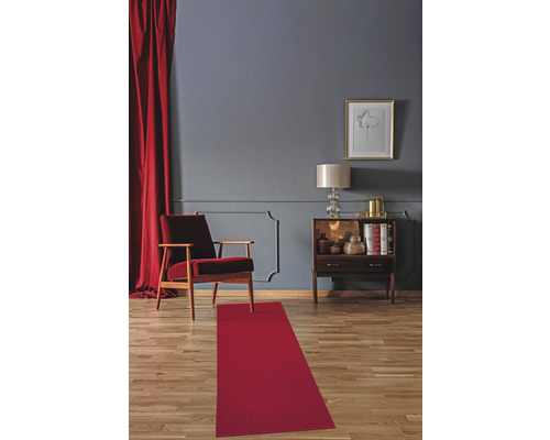 Wohnzimmer mit Teppichläufer, Sessel und Kommode