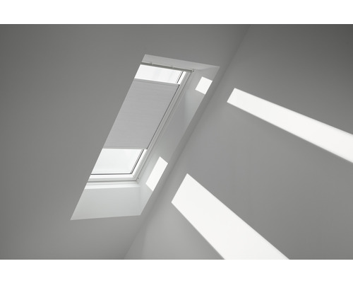 Velux Wabenplissee weiß uni manuell FHC C02 1045SWL Dachfenster mit teilweise geschlossenem Plissee in einem Dachgeschossraum.