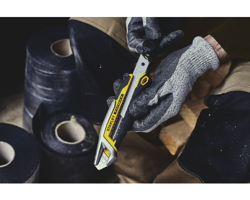 Stanley Fatmax Cuttermesser in der Hand mit Arbeitshandschuhen