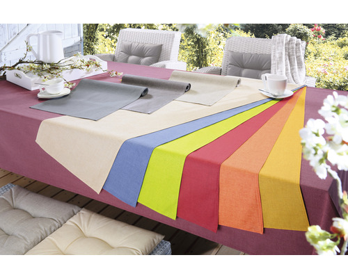 Szene mit Esstisch im Freien, gedeckt mit Tischdecke und Tischläufern in verschiedenen Farben