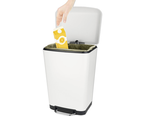 Weißer Treteimer mit Müllbeutel und Hand, die eine Saftpackung hineinwirft.