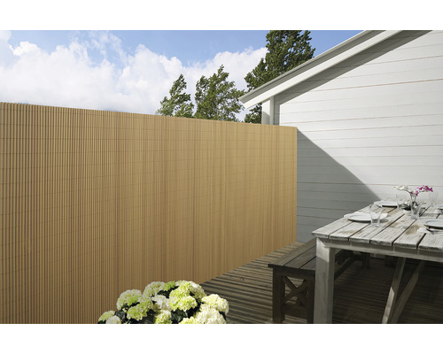 Außenbereich mit Sichtschutzzaun, Terrassentisch und Blumen