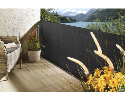Terrasse mit Sichtschutzzaun, Korbsessel und Pflanzen