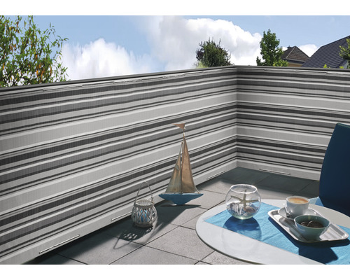 Balkon mit Windschutz in Streifenoptik und dekoriertem Tisch
