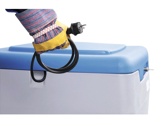 Hand mit Handschuh hält Stecker über Wasserenthärteranlage