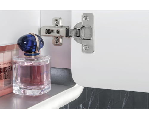 Scharnier an einem weißen Schrank mit Kosmetikprodukten