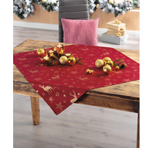 Weihnachtliche Tischdekoration mit roter Tischdecke, Hirschmotiven und Sternen auf Holztisch.