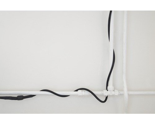 Installation mit Elektrokabel und Wasserrohr vor weißem Hintergrund