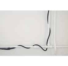Installation mit Kunststoffrohren und einem Elektrokabel an einer Wand