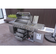 Edelstahl Gasgrill mit offenen Türen und Schubladen auf einer Terrasse