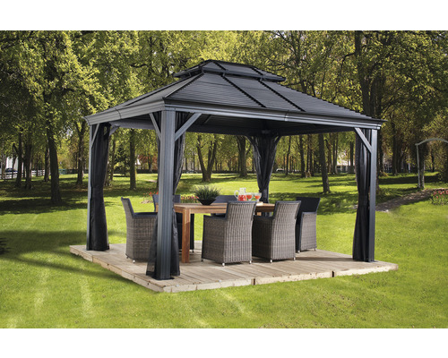 Pavillon SOJAG Mykonos 10x12 inkl. Moskitonetz 299 x 364 cm grau Gartenpavillon mit Vorhängen, Tisch und Stühlen auf einer Terrasse im Garten.