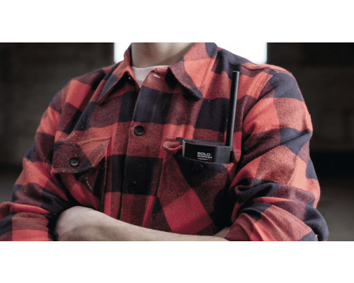 Eine Person mit einem Alleinarbeiter-Sicherheitsgerät in der Hemdtasche.