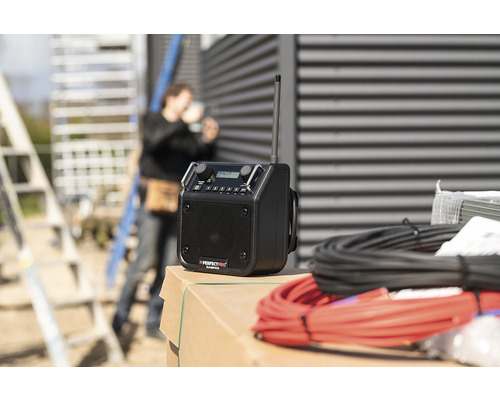 Baustellenradio mit Antenne und Kabeln im Hintergrund Bauarbeiter