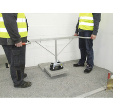 Zwei Bauarbeiter transportieren eine Betonplatte mit einem Vakuumheber.