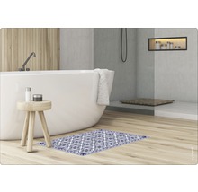 Badezimmer mit Badewanne, Hocker und gemusterter Badematte