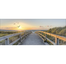 Holzsteg führt zum Strand bei Sonnenuntergang