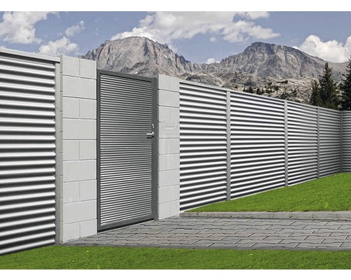 Ansicht eines Zauns aus Metall mit einem Tor vor einer Bergkulisse