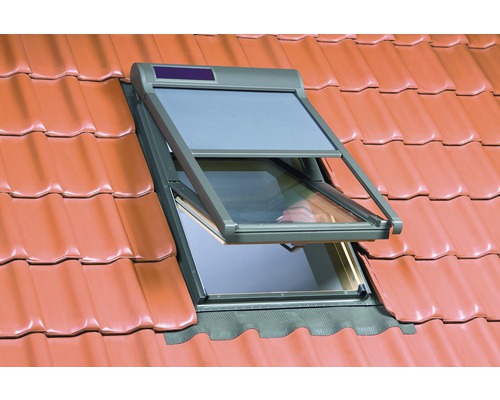 Geöffnetes Dachfenster mit Rollladen auf einem Ziegeldach