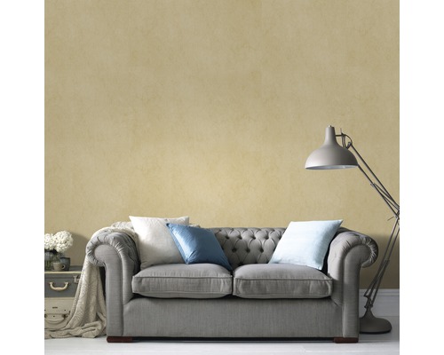 Wohnzimmer mit grauer Couch, Kissen und Stehlampe vor einer strukturierten Wand