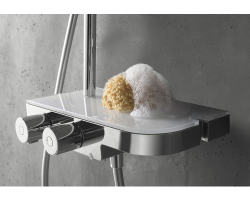 Brausethermostat mit Ablage, Badeschwamm und Schaum auf einem grauen Untergrund.