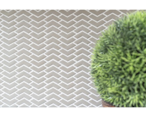 Fliesenwand mit Fischgrätenmuster und Pflanze