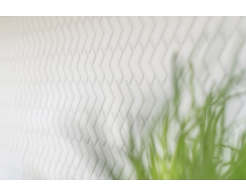 Weiße Ziegelwand mit Fischgrätenmuster