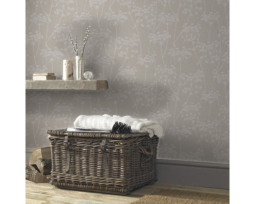 Gemütliches Zimmer mit floral gemusterter Tapete, Weidenkorb und Holzboden