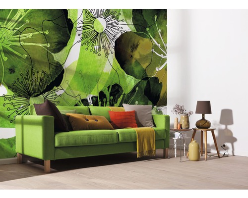 Wohnzimmer mit grüner Couch, Kissen und einer Fototapete mit Pflanzenmotiven