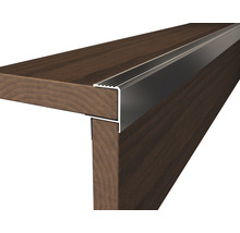 Detailaufnahme einer Treppenkante aus Metall auf einer Holztreppe.