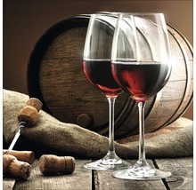 Zwei Weingläser mit Rotwein, Korkenzieher, Korken und Weinfass auf Holztisch