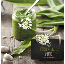 Bärlauchpesto im Glas mit frischen Zutaten und einer Tafel mit der Aufschrift Frische und gesunde Lebensmittel