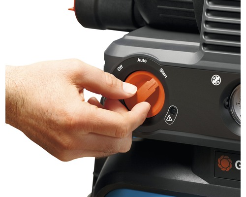 Eine Hand dreht den orangefarbenen Drehknopf eines Kompressors auf die Startposition.