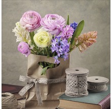 Blumenstrauß in Papiertüte mit Schleife und Spulen auf Büchern