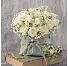 Arrangement aus Rosen und Schleierkraut in Papierverpackung auf einem Buch