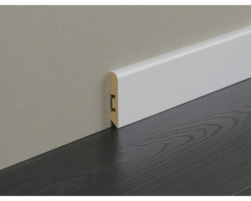 Weiße Sockelleiste aus Holz an einer Wand und einem dunklen Holzboden