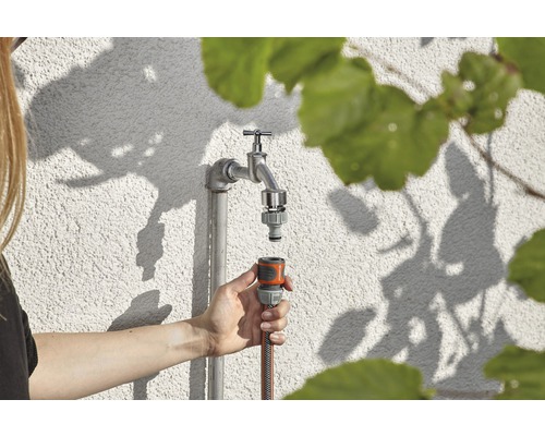 Gartenszene mit Wasserhahn und Schlauchanschlussstück