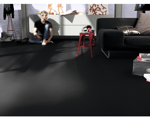 Wohnzimmer mit dunklem Vinylboden, Sofa und sitzendem Mann