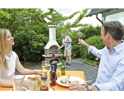 Grillparty im Garten mit gemauertem Gartengrill und feiernden Menschen